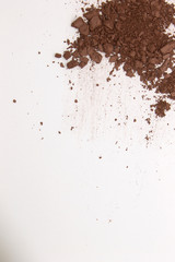 This is a photograph of a Dark Brown Powder Eyeshadow isolated on a White Background