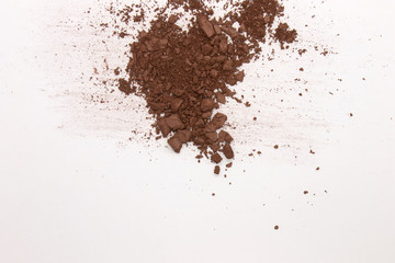 This is a photograph of a Dark Brown Powder Eyeshadow isolated on a White Background