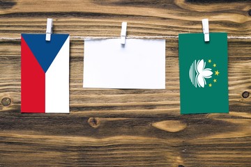 Hanging flags of Czech Republic and Macao attached to rope with clothes pins with copy space on...