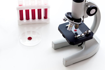 Blood testing laboratory. Samples viewing under microscope near tubes on white background top view