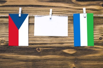Hanging flags of Czech Republic and Sierra Leone attached to rope with clothes pins with copy space...