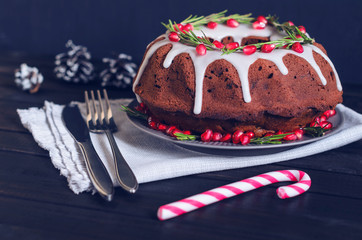 Homemade chocolate Christmas cake decorated with rosemary and pomegranate, front view