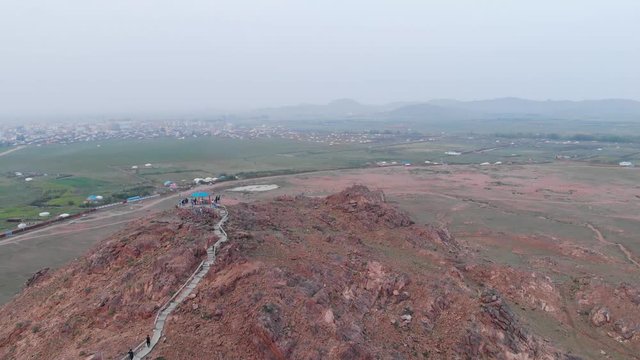 Aerial Flyover Prayer Flags on Red Rocky Mountain Point in Mongolia