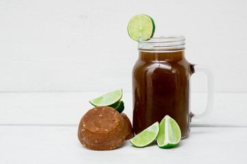 panela water with lemon on white wooden boards