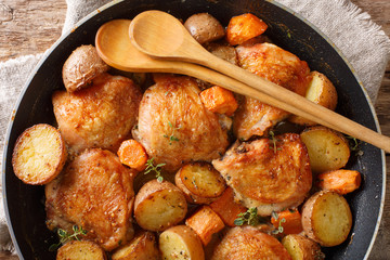 baked chicken pieces with vegetables and herbs close-up in a pan. Horizontal top view