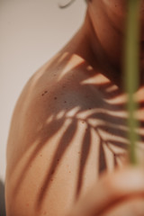 Shadow of palm tree on girl bare shoulder