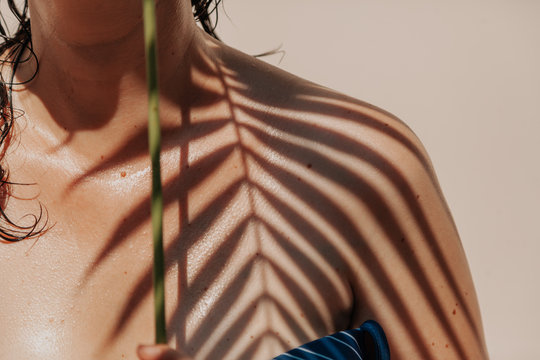 Shadow of palm tree on girl bare shoulder