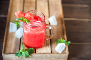 Close-up of watermelon and mint smoothie in a jar. Watermelon cooling drink. Summer cocktail in a jar and copy space.