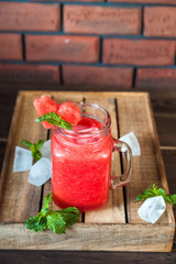 Close-up of watermelon and mint smoothie in a jar. Watermelon cooling drink. Summer cocktail in a jar and copy space.