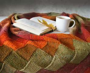 knitted blanket, coffee, book and autumn leaf