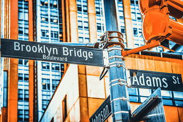 Street sign (nameplate) of Brooklyn Bridge and Adams Street and urban cityscape of New York. USA. - obrazy, fototapety, plakaty