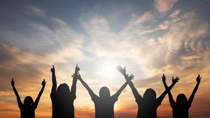 A group of people raised their hands freely and freely. With abstract sunset conceptual background