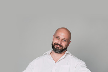 Handsome middle-aged man on grey background looking at camera.  with copy space