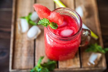 Close-up of watermelon and mint smoothie in a jar. Watermelon cooling drink. Summer cocktail in a jar and copy space.