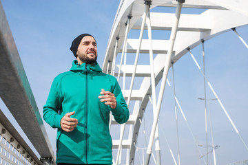 Athletic young man running outdoors