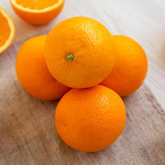 Fresh ripe organic oranges on a white wooden surface, side view. Closeup.
