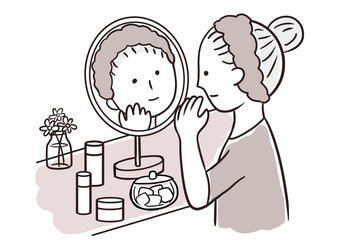 鏡を見てスキンケアをする女性