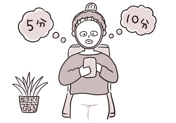 スマホを見ながらフェイスパックする女性