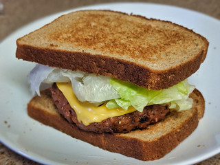 Vegan, Vegetarian-Friendly Meatless Burger with Toppings and a Side of Broccoli on a White Plate