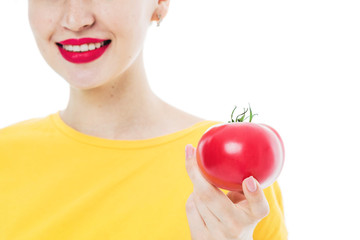 portrait of a young, beautiful, girl with a tomato in her hands.