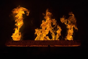 Closeup of a red hot iron with flames and black background