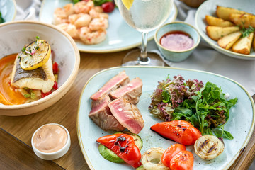 Medium rare tuna with lettuce and hot sauce. Restaurant menu. Variety of dishes on the table. Restaurant menu. Italian cuisine