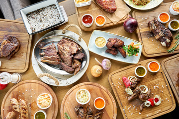 Barbecue restaurant menu. Many different food on the table. Dinner party or Banquet. Top view