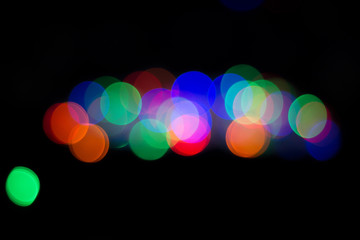 Multicolored blured circle bokeh on black background