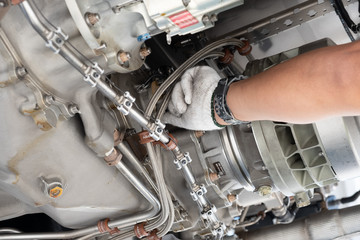 Fototapeta premium Gas turbine engine close up during maintenance when airplane park at the airport.Mechanic and technician repair hydraulic and check system of power plant.