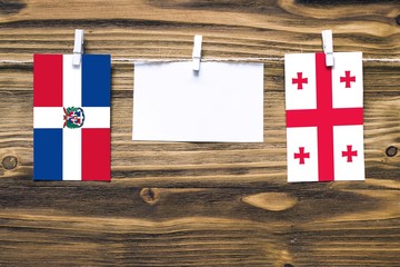 Hanging flags of Dominican Republic and Georgia attached to rope with clothes pins with copy space...