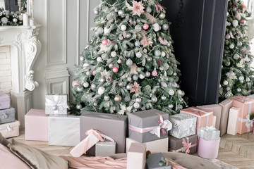 Many Christmas gifts under tree with ornaments. Christmas balls, ribbon bow, snowflakes, pine cones and lights.