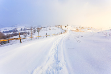 Heavy snowfall in morning in the mountains, rural landscape. Freezing day concept