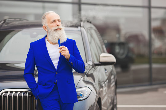 Old stylish man in the luxury car. Male with beard and mustash driving automobile. car sales salon.