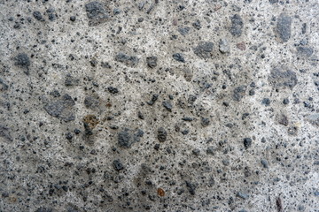 Detail of surface texture with small pebble rock on dirty ground.Texture of concrete floor in at car park. Surface grooved vertical pattern, Rough and rugged on street,Grey color, Wallpaper background