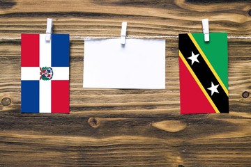 Hanging flags of Dominican Republic and Saint Kitts And Nevis attached to rope with clothes pins...