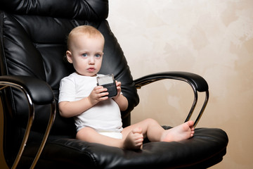 little child sits in an office chair with a text stamp in his hands
