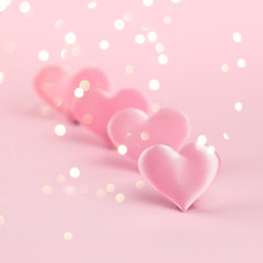 Pink silk heart on a pink background is standing in line. The concept of minimalism. Place for text. Pastel colors .