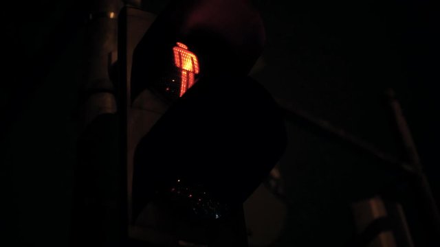 closeup of red pedestrian traffic light in night time dark symbol to not cross street