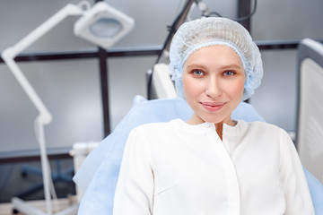 Cosmetology Service. Young patient in hair cap at beauty clinic close-up smiling confident