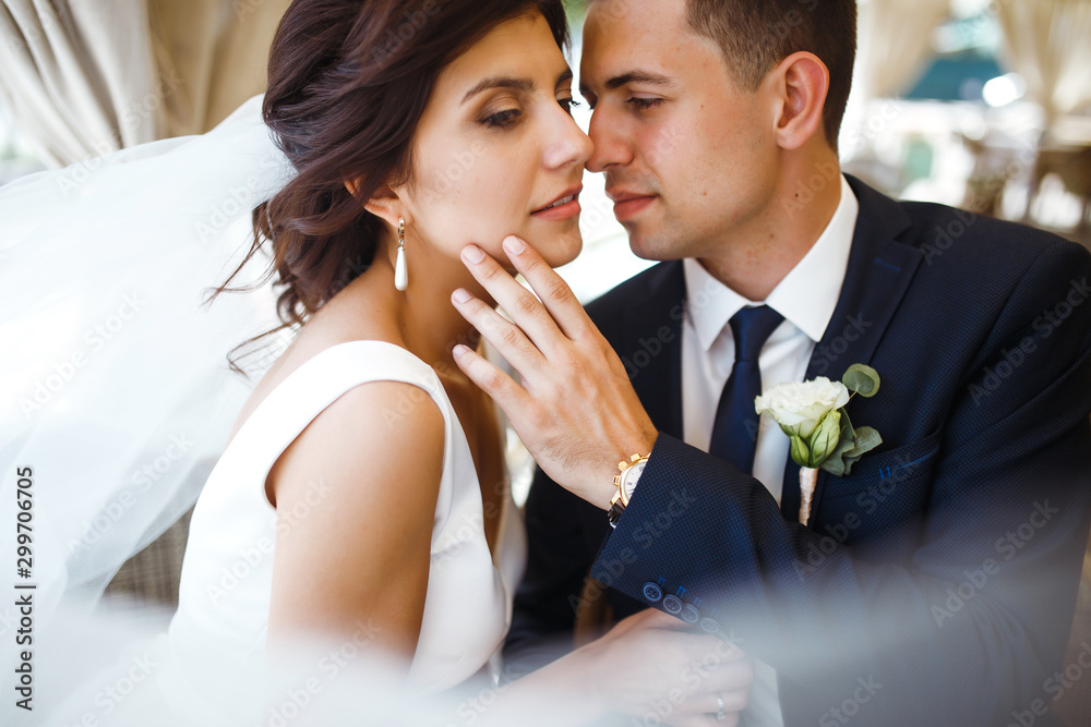 Wall mural young bride and groom in a cafe. husband and wife hold each other's hands. loving couple in a restau