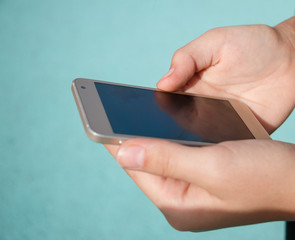 The girl's hands hold the phone smartphone and control the fingers