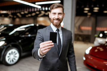 Salesman with key at the car dealership