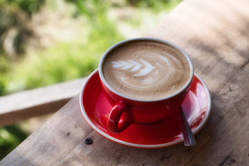 Top view of cappuccino art in red coffee cup. Close up on top view.
