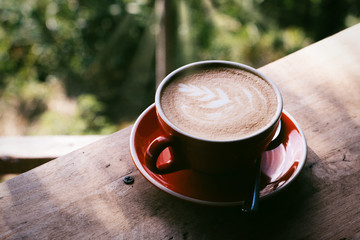 Top view of cappuccino art in red coffee cup. Close up on top view.