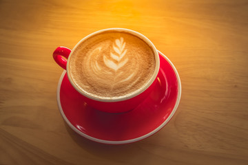 Top view of cappuccino art in red coffee cup. Close up on top view.