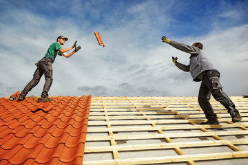 Roofer at work, installing clay roof tiles, Germany