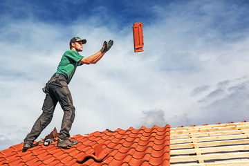 Roofer at work, installing clay roof tiles, Germany