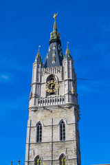 Vertical picture of the medieval tower of the Belfry (Het Belfort) of Ghent taken from Sint-Baafsplein, in Belgium, Europe, during a sunny day. Tallest bell tower in Belgium with 91-meters high