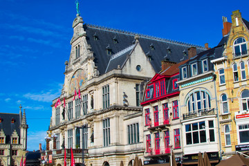 Fototapeta na wymiar Ghent, Belgium; 10/26/2019: Nederlands Toneel Gent (NTGent or NTG), a famous theatre in Sint-Baafsplein square, with traditional colorful belgian houses during a sunny day