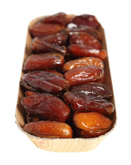 Dry dates in box. Isolated with clipping path. Macro.